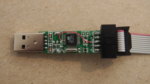 The PCB with modification for programming The guts of the programmer showing the temporary tiny wire modification